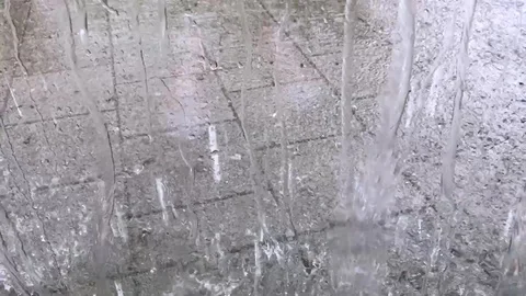 Many raindrops falling on pavement in city Stock Footage 120138109