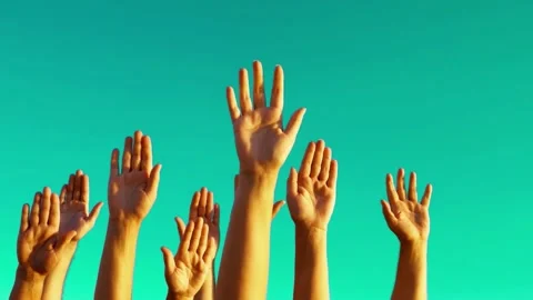 Many raised hands waving in slow motion against a clear blue sky. Stock Footage 342419057