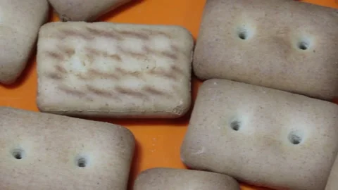 Many rectangular biscuits with small pores in red plate Stock Footage 145338261