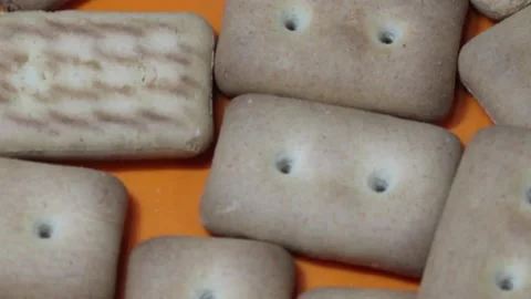 Many rectangular biscuits with small pores in red plate Stock Footage 145862493