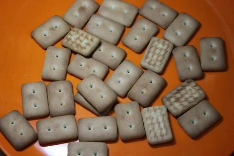 Many rectangular biscuits with small pores in red plate Foto stock