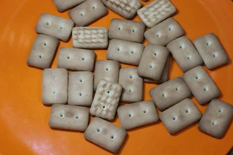 Many rectangular biscuits with small pores in red plate Stock Photos