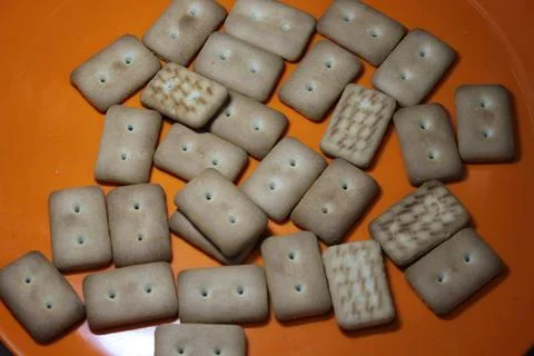 Many rectangular biscuits with small pores in red plate Foto stock