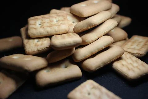 Many rectangular biscuits with small pores on black floor Stock Photos