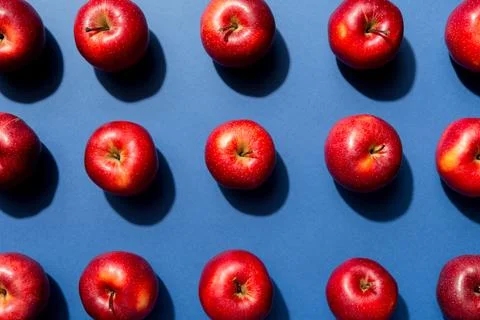 Many red apples on colored background, top view. Autumn pattern with fresh ap Stock Photos