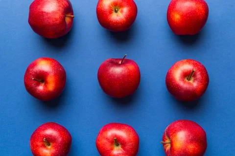 Many red apples on colored background, top view. Autumn pattern with fresh ap Stock Photos