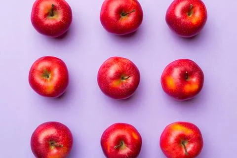 Many red apples on colored background, top view. Autumn pattern with fresh ap Stock Photos