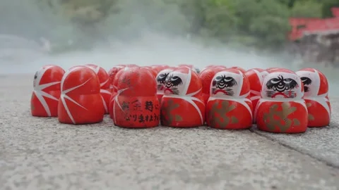Many red Daruma dolls rest on stone platform at Katsuoji Temple in Osaka Stock Footage 344279071