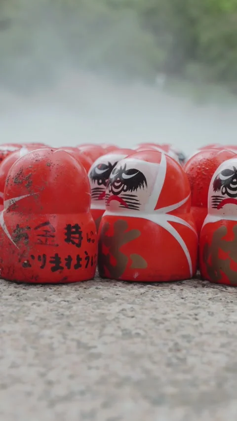 Many red Daruma dolls rest on stone platform at Katsuoji Temple in Osaka Stock Footage 345740694