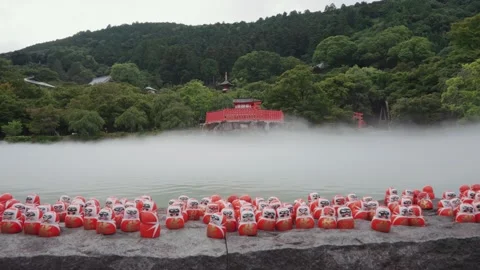 Many red Daruma dolls on stone platform at Katsuoji Temple in Osaka, surrounded Stock Footage 345189044