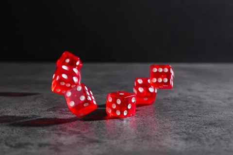 Many red game dices falling on grey textured table. Space for text Stock Photos