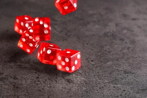 Many red game dices falling on grey textured table. Space for text Stock Photos