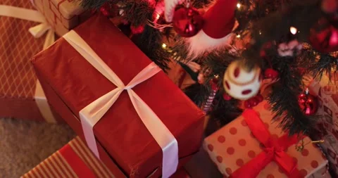 Many red gift boxes near decorated Christmas tree on eve, camera in motion. Stock Footage 144242852