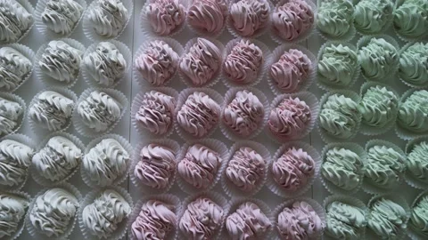 Many red, green and white cooked marshmallows lie on the table. Camera zooming Stock Footage 218193791