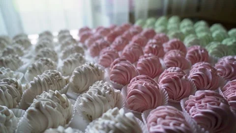 Many red, green and white cooked marshmallows lie on the table. Camera rotating Stock Footage 221018006
