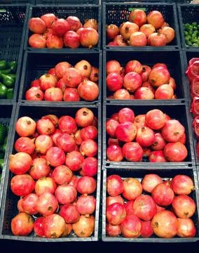 Many red pomegranates in the boxes close-up Stock Photos