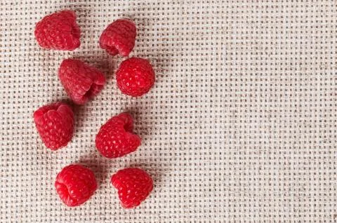 Many red ripe raspberry fruit, on gray linen table cloth with copy space desi Stock Photos