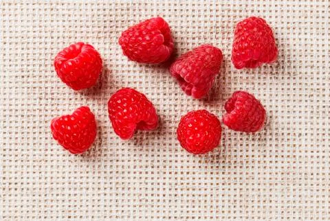 Many red ripe raspberry fruit, on gray linen table cloth with copy space desi Stock-Fotos