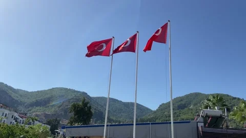 Many red turkish flags with red and white moon waving on blue sky and mount.. Stock Footage 307698852