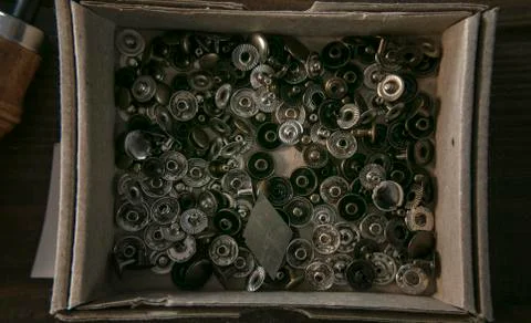 Many rivet of different diameter perfect for leather goods in cardboard box. Stock Photos