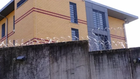 Many rows of barbedwire, high concrete fence, barbed wire fence on top, build Stock Footage 172796519