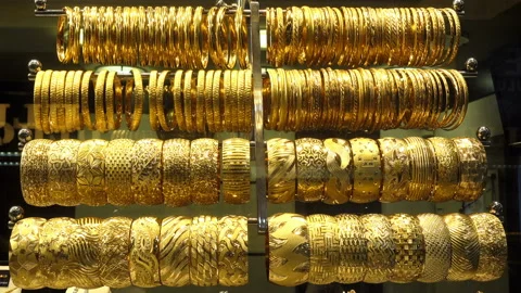 Many rows of gold bracelets hang on coasters in 4k Stock Footage 126143876