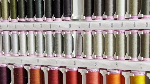 Many rows of spools for threads of different colors for sewing machines and Stock Footage 250112854