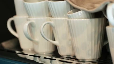 Many rows of white coffee cup with saucer and teaspoon on table and coffee maker Stock Footage 237522579