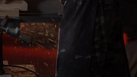 Many sawdust fly from under the machine while worker create product 100 fps Stock Footage 120601643
