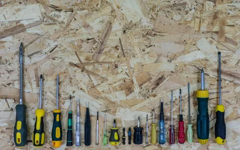 Many screwdrivers from small to large, arranged in size on the OSB plate. Stock Photos