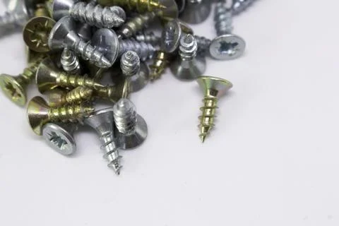 Many self-tapping screws of different colors on a white background Stock Photos