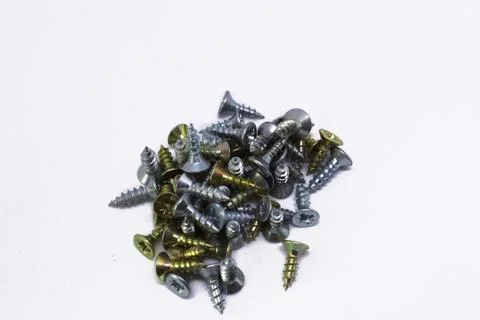 Many self-tapping screws of different colors on a white background Stock Photos