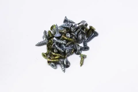Many self-tapping screws of different colors on a white background Stock Photos