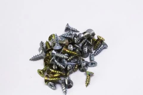 Many self-tapping screws of different colors on a white background Stock Photos