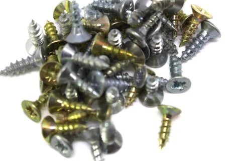 Many self-tapping screws of different colors on a white background Stock Photos