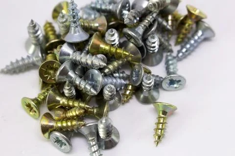 Many self-tapping screws of different colors on a white background Stock Photos