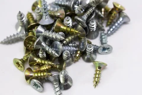 Many self-tapping screws of different colors on a white background Stock Photos