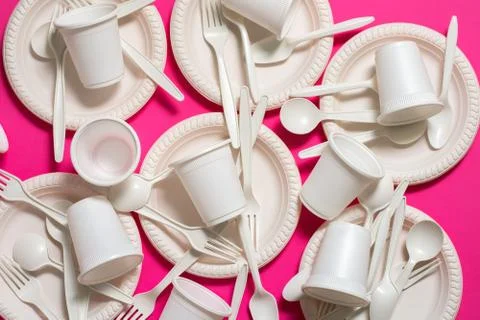Many sets of biodegradable disposable tableware on a pink background. Stock Photos