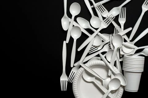 Many sets of biodegradable disposable tableware on a black background. Stock Photos