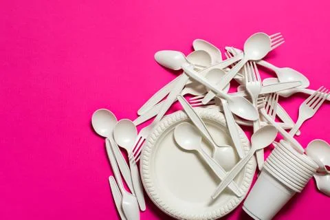 Many sets of biodegradable disposable tableware on a pink background. Stock Photos