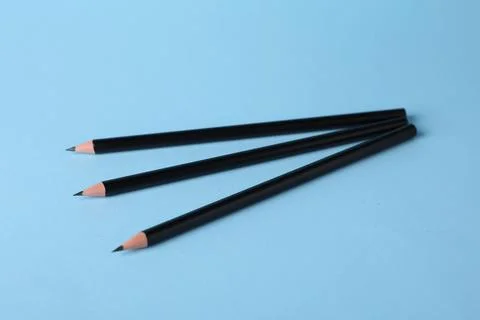 Many sharp graphite pencils on light blue background, closeup 库存照片