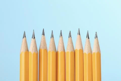 Many sharp graphite pencils on turquoise background, space for text. Macro vi Stock Photos