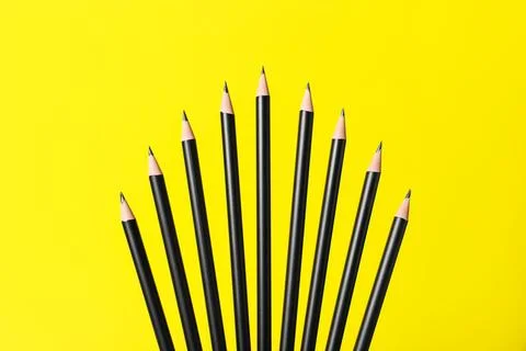 Many sharp graphite pencils on yellow background 写真素材
