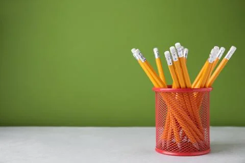 Many sharp pencils in holder on light table against green background, space.. Stock Photos
