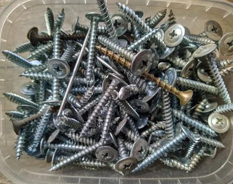 Many silver self-tapping screws closeup photo top view Fotos Stock