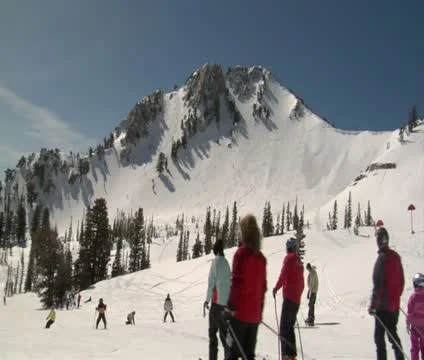 Many skiiers glide down mellow hill, blue sky Stock Footage 21672901