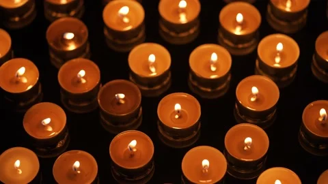Many small burning candles on a black background Stock Footage 176475679
