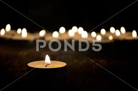 Many small christmas candles burning at dark. Shallow depth of field Stock Photos
