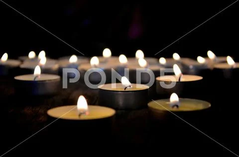 Many small christmas candles burning at dark. Shallow depth of field Stock Photos