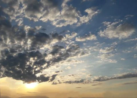 Many small clouds all over the frame and the sun is not bright below Stock Photos